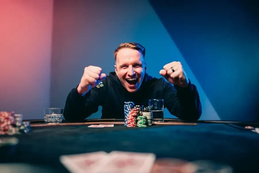Benjamin Rolle celebrating a WSOP Online Millionaire Maker victory at home with a virtual final table display