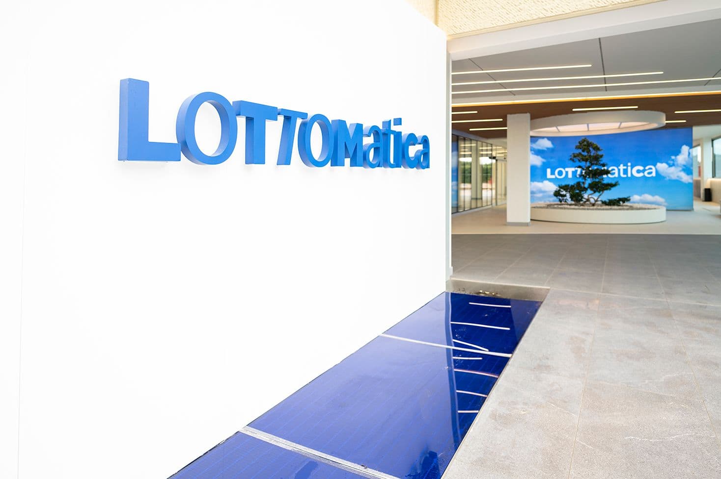Merged logo of Lottomatica and CIRSA over a background of financial graphs and maps of Europe and Latin America