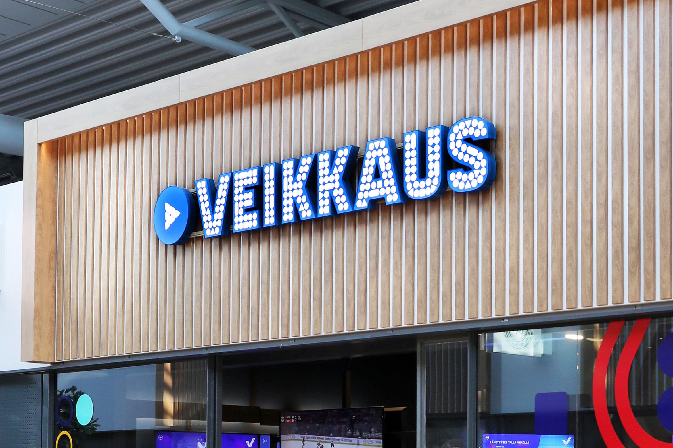 Offices of Veikkaus with revenue and international expansion graphics highlighted on screen