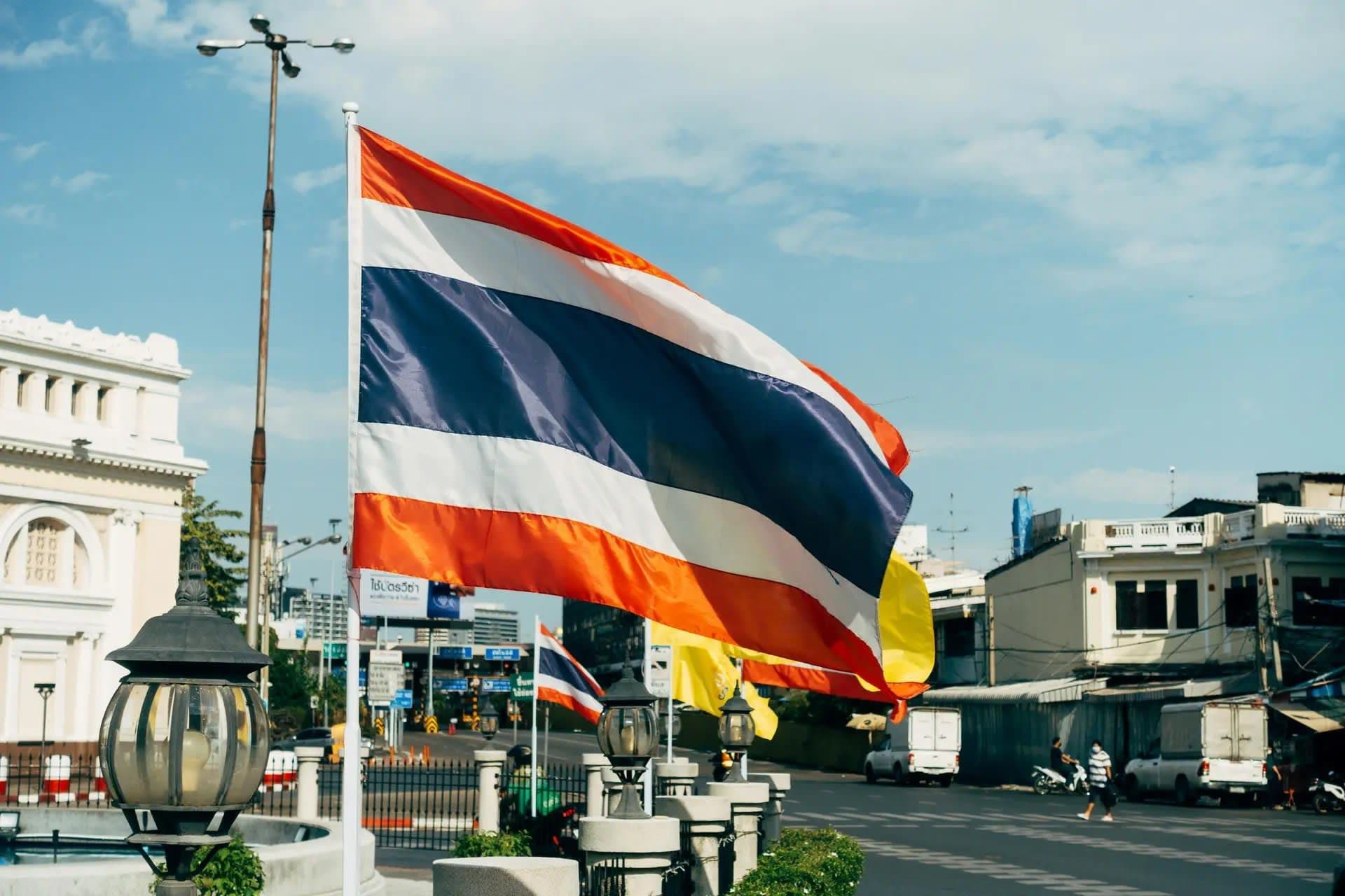 Police officers detaining a man outside a Bangkok boxing stadium amid an online betting investigation