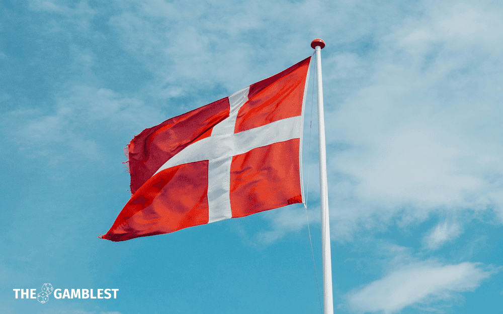 Danish flag beside a regulatory document and advertising billboards by a public transport stop near a school