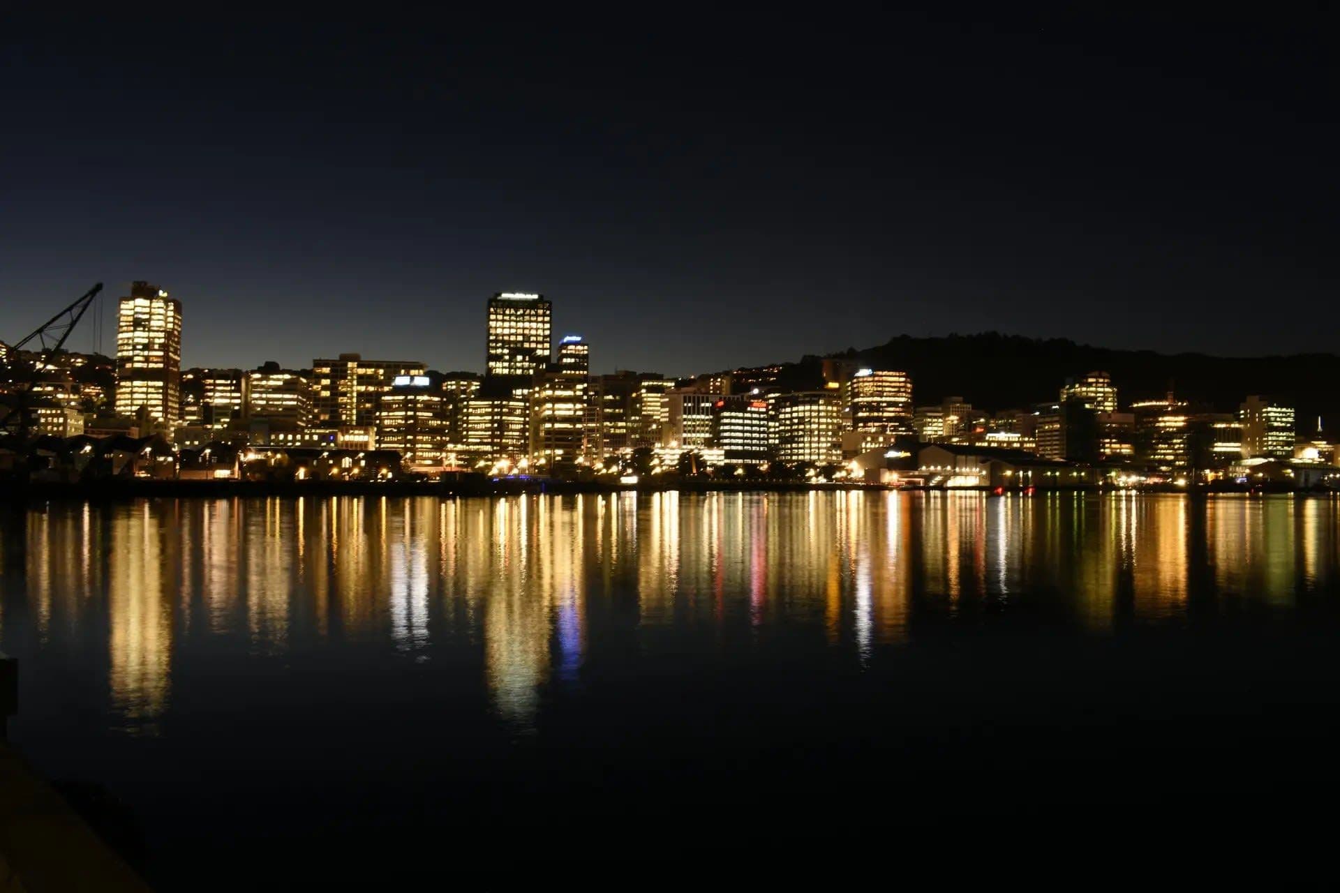 Fachada del Grand Hotel en Auckland con el logo de SkyCity y documentos financieros sobre una mesa