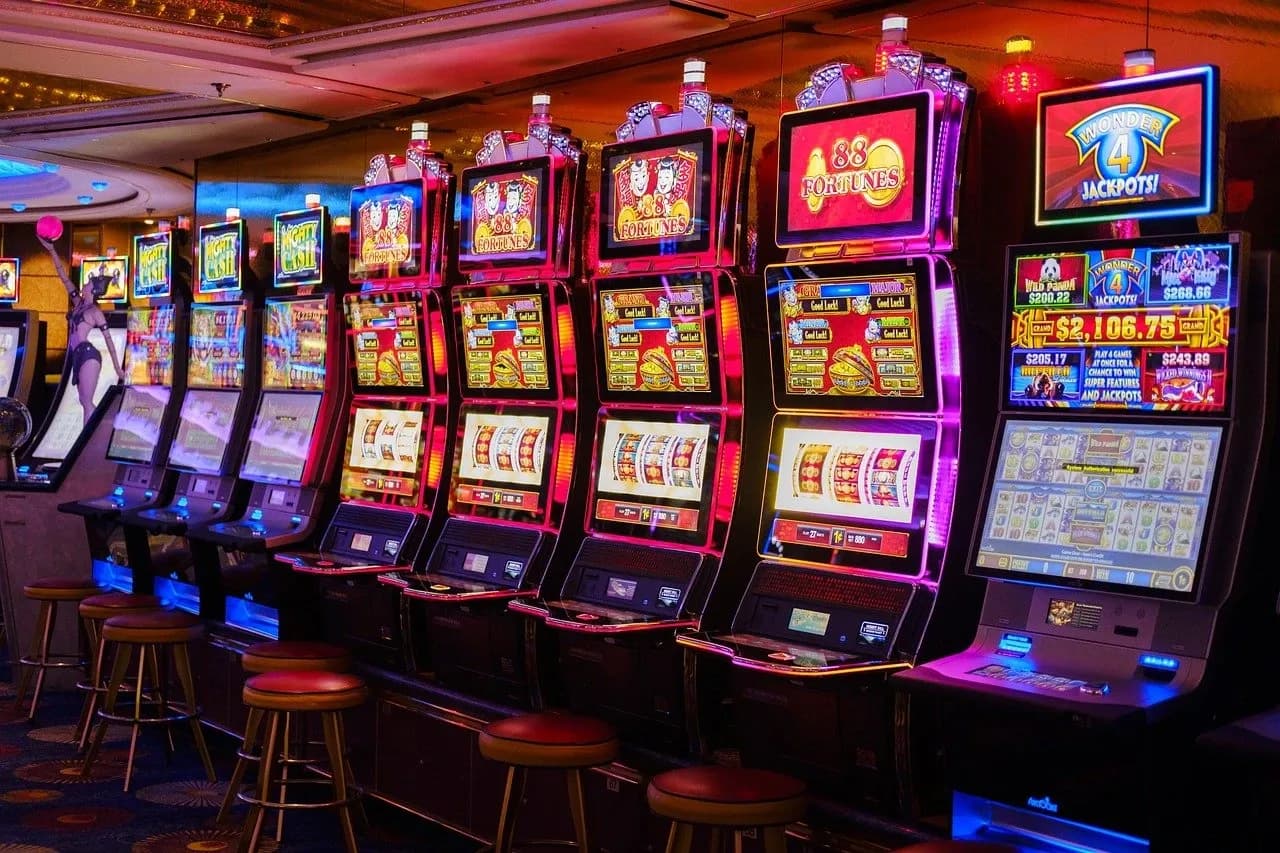 Interior of an adult gaming centre with rows of gaming machines and illuminated screens on a high street evening
