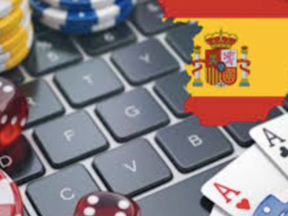 Hands holding a bank card and a smartphone showing a gambling account on a blue background with Spanish flag tones
